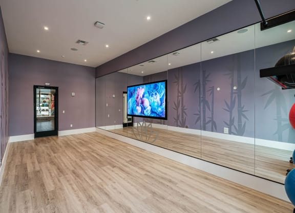a large room with mirrored walls and a tv in the middle at Altis Grand Kendall, Miami