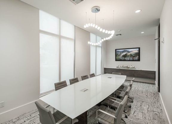 a conference room with a long white table and chairs at Altis Grand Kendall, Miami