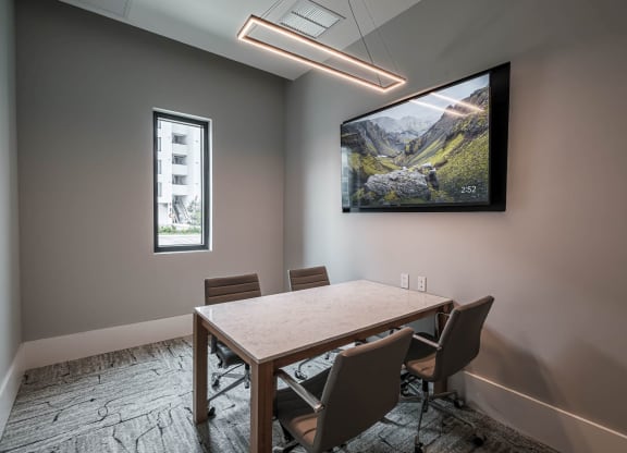 a conference room with a tv and a table with chairs at Altis Grand Kendall, Florida 