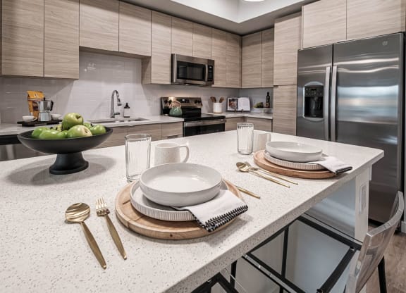 a kitchen with stainless steel appliances and white counter tops at Altis Grand Kendall, Miami, FL