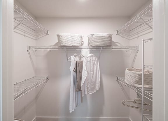 a walk in closet with wire shelves and clothes at Altis Grand Kendall, Florida
