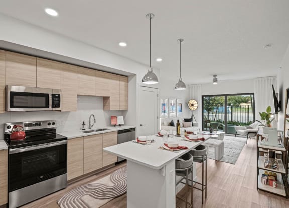 an open kitchen and living room with a table and chairs at Altis Grand Kendall, Miami, FL