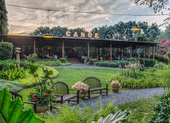 A Canopy restaurant with a garden in front.