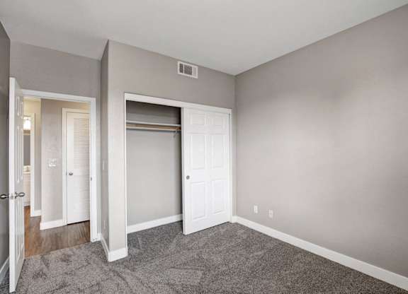 A room with a white door and a carpeted floor.