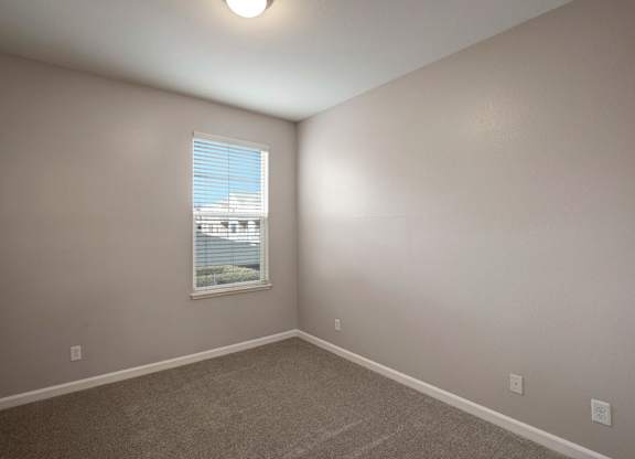 A room with a window and a car parked outside.