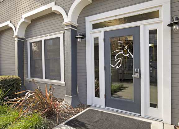 A grey house with a glass door and a window.
