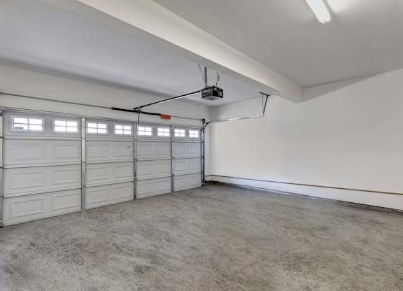 A spacious garage with a white ceiling and a grey floor.
