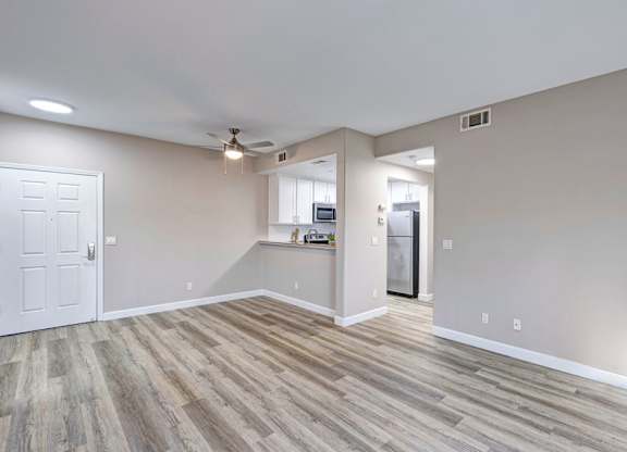 A room with a white door and a wooden floor.