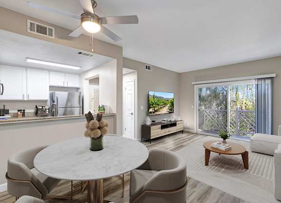 A modern living room with a dining table and chairs.