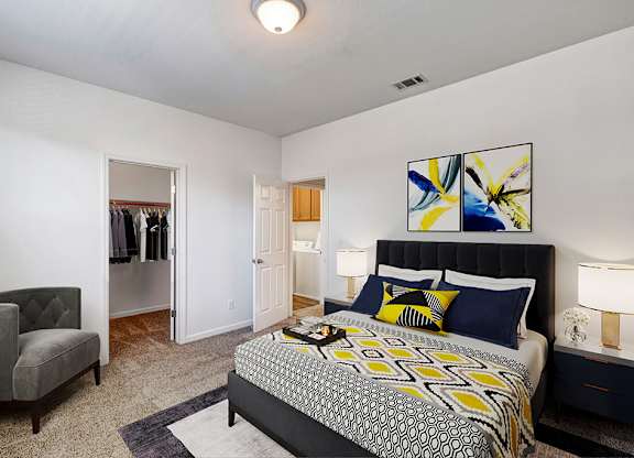 A bedroom with a large bed and a chair.