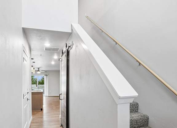 A hallway with a staircase and a skylight.