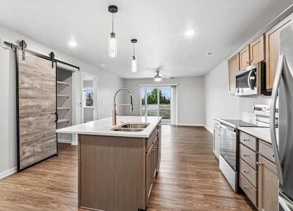 A modern kitchen with wooden cabinets and a large island.