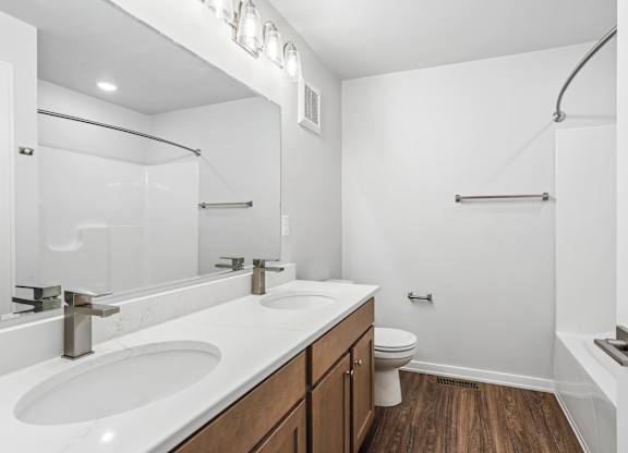 A white bathroom with a sink, toilet, and bathtub.