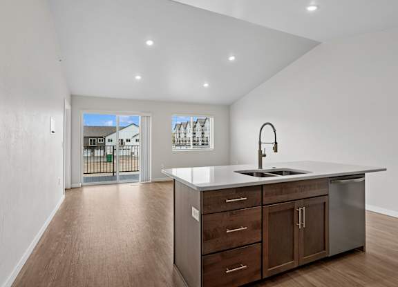 A kitchen with a sink, stove, and cabinets.