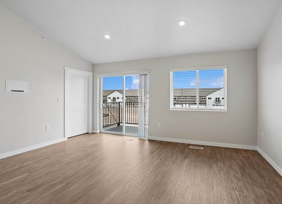 A room with a sliding glass door leading to a balcony.