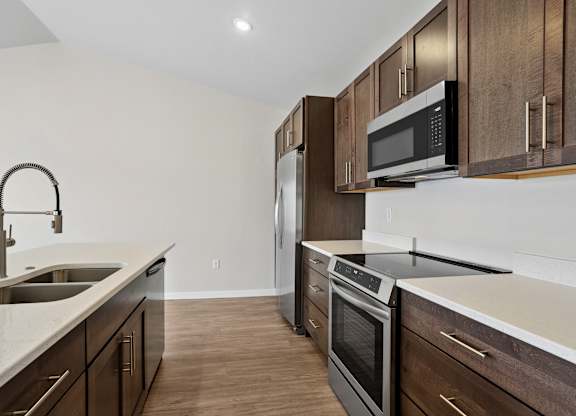 A kitchen with a sink, stove, and refrigerator.