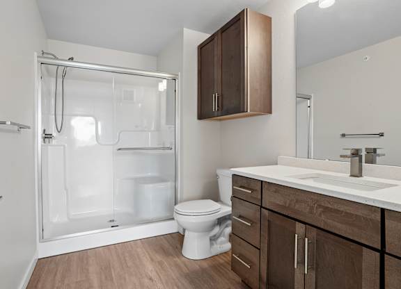A bathroom with a toilet, sink, and shower.