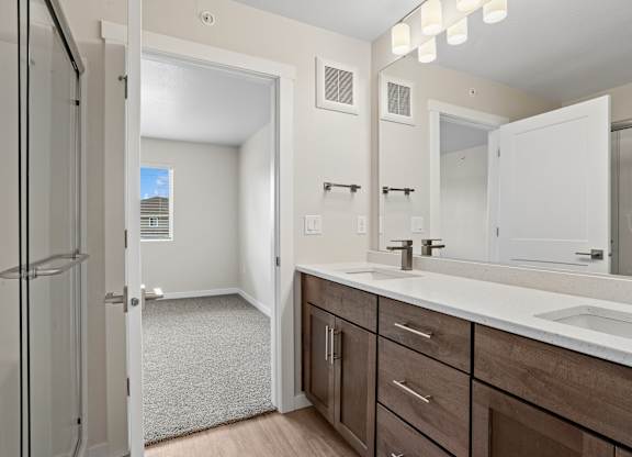 A bathroom with a white sink and brown cabinets.