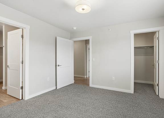 A room with white walls and a grey carpet.