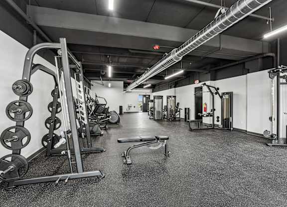 A black and white photo of a gym with various exercise equipment.