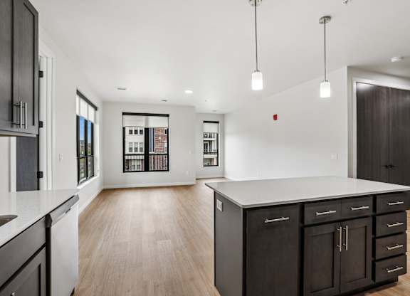 A modern kitchen with dark wood cabinets and a white island.