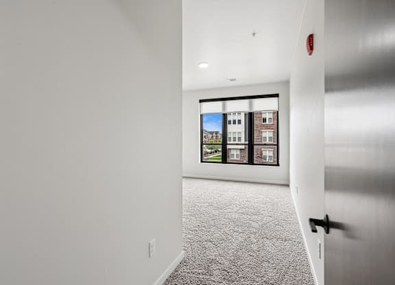 A white hallway with a picture of a building on the wall.