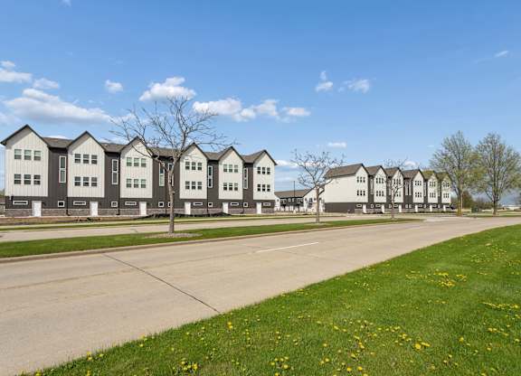 A row of houses with a tree in front of the first house.