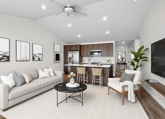 A living room with a white couch, a black coffee table, and a ceiling fan.