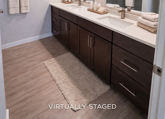 A bathroom with a vanity, mirror, and towels.