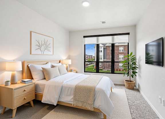 A bedroom with a large bed and a window overlooking a building.