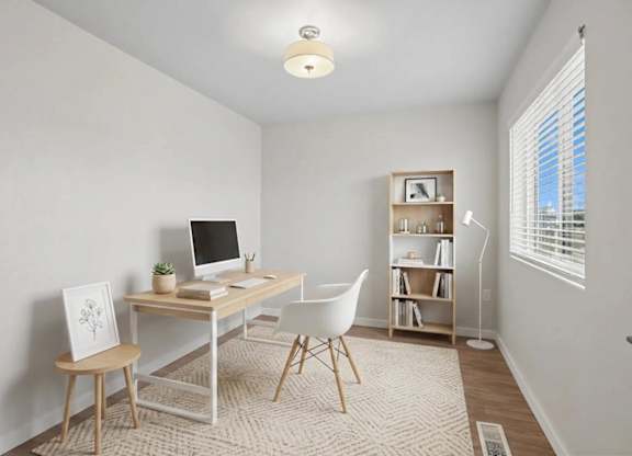 A room with a desk, chair, and bookshelf.
