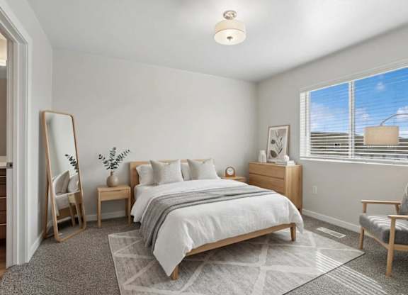A bedroom with a large bed, a chair, and a mirror.