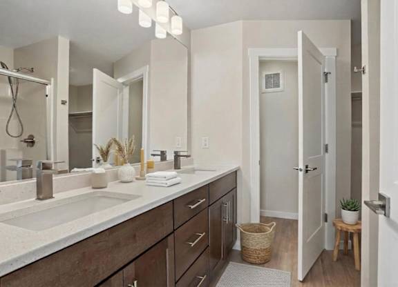 A bathroom with a sink, mirror, and wooden cabinets.
