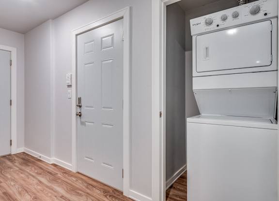 a laundry room with a washer and dryer and a white door