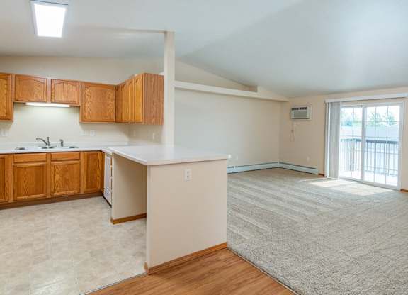 Kitchen with Open Concept Living Area with A/C Unit and Balcony