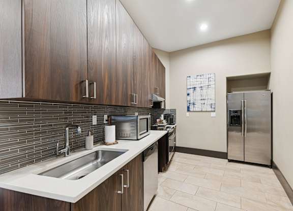 A kitchen with a sink, microwave, and refrigerator.