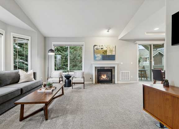 A modern living room with a fireplace and a painting on the wall.
