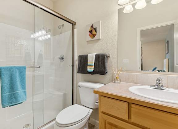 A bathroom with a toilet, sink, and shower.
