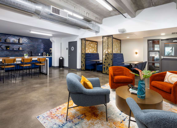 a living room with couches chairs and tables and a kitchen