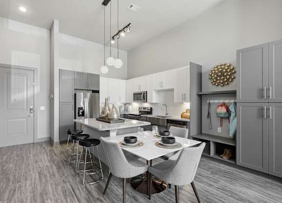 A modern kitchen with a dining table and chairs.
