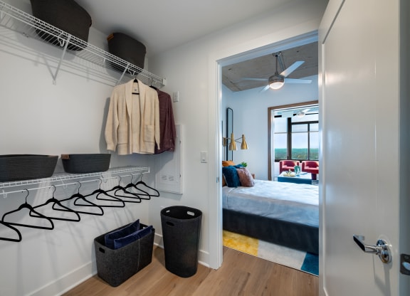 a bedroom with a bed and a closet with shelves and hooks