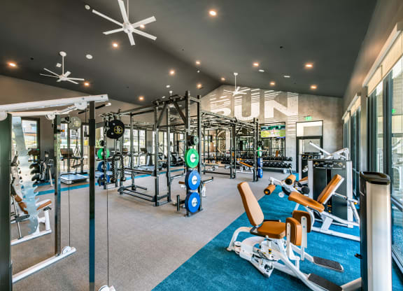a gym with weights and cardio equipment and a sign on the wall