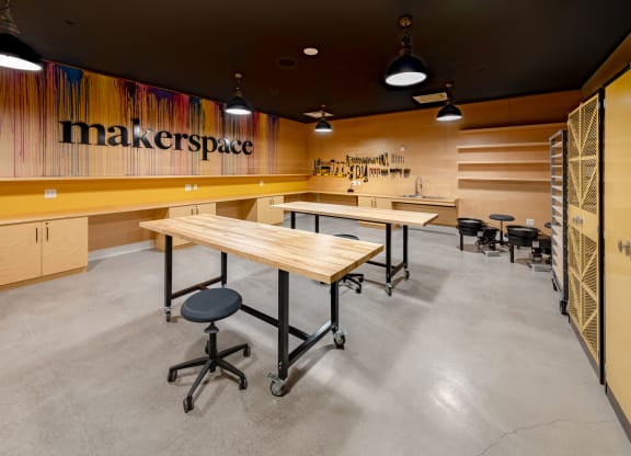 a communal table in a maker space with desks and chairs