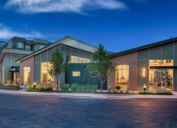 A modern building with a parking lot in front.