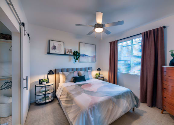 a bedroom with a bed and a ceiling fan