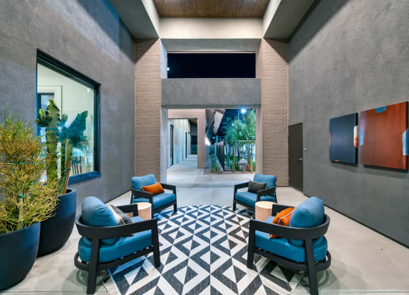 a lobby with blue chairs and a geometric rug