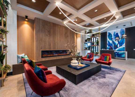 a living room with red chairs and a fireplace