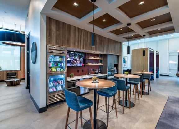 a lobby with tables and chairs and a bar with a television