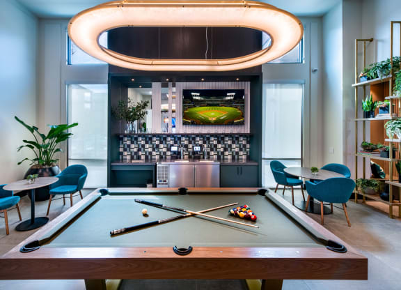 a pool table in a room with a bar and a television