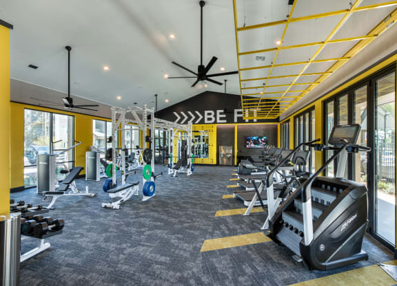 a gym with treadmills and other exercise equipment in the lobby of a building